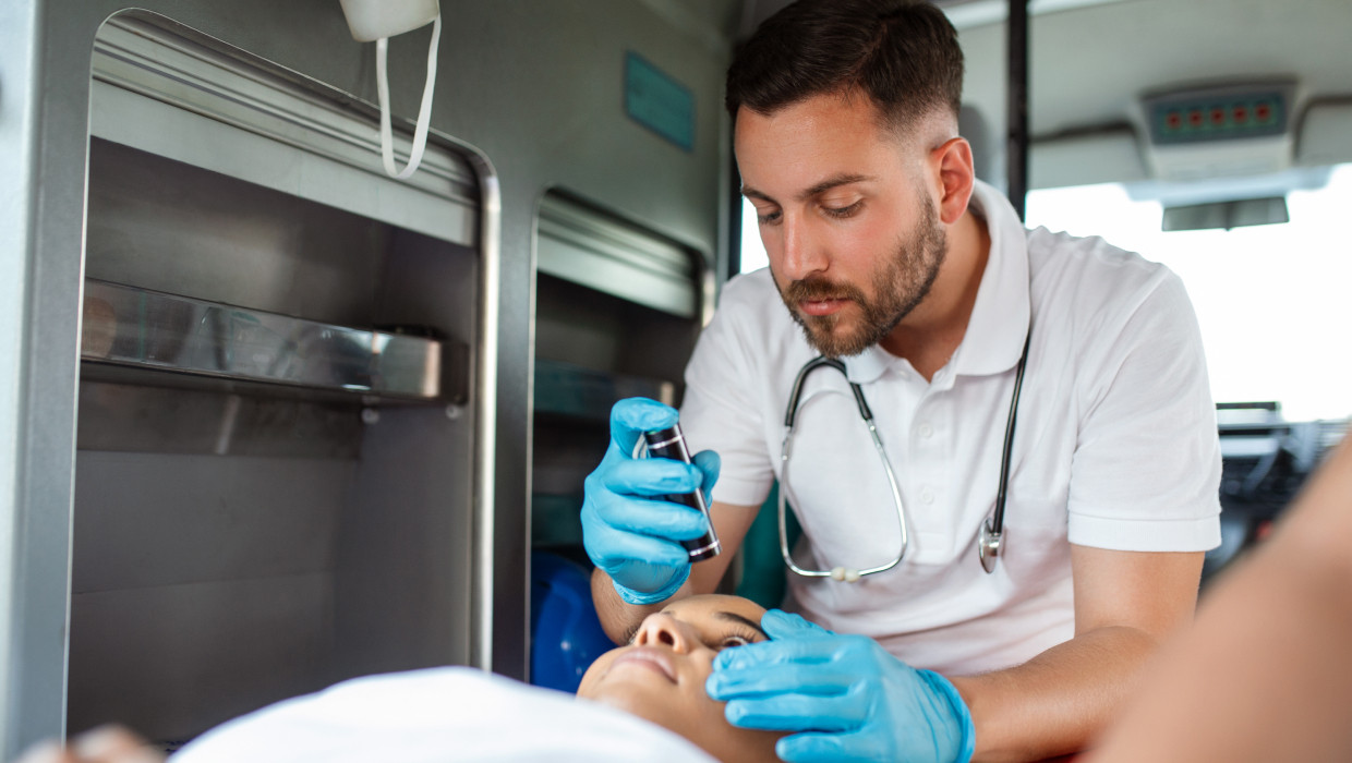 Paramédico atendiendo a una paciente en el interior de una ambulancia