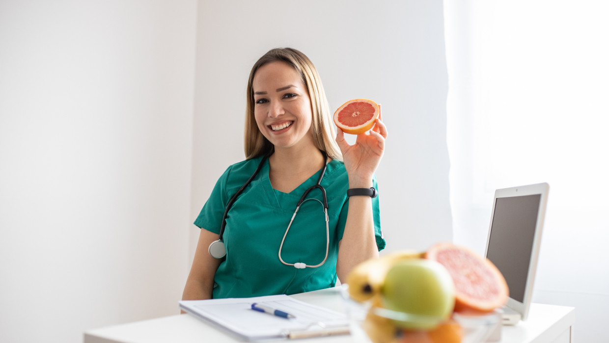 Nutricionista con frutas en un escritorio