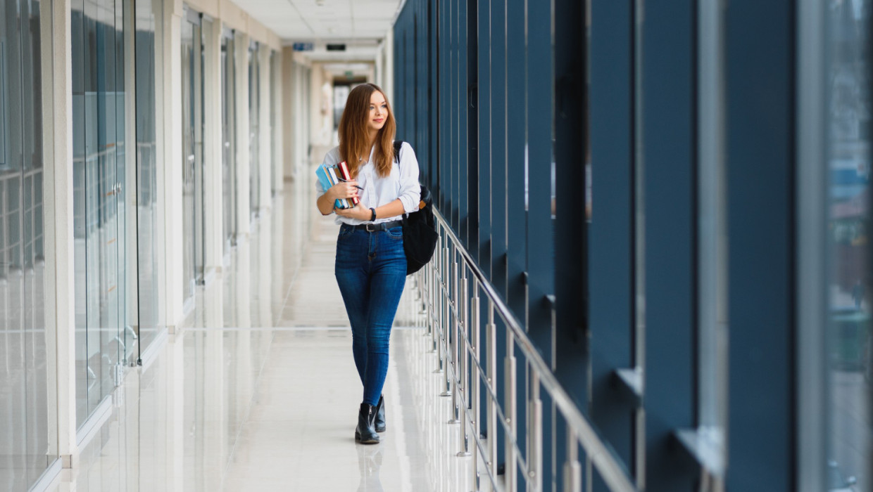 chica estudiante alegre en pasillo de la universidad