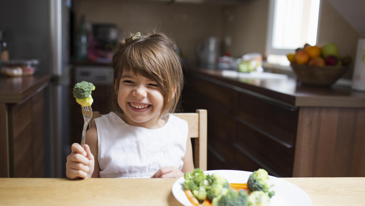 Niña comiendo verduras