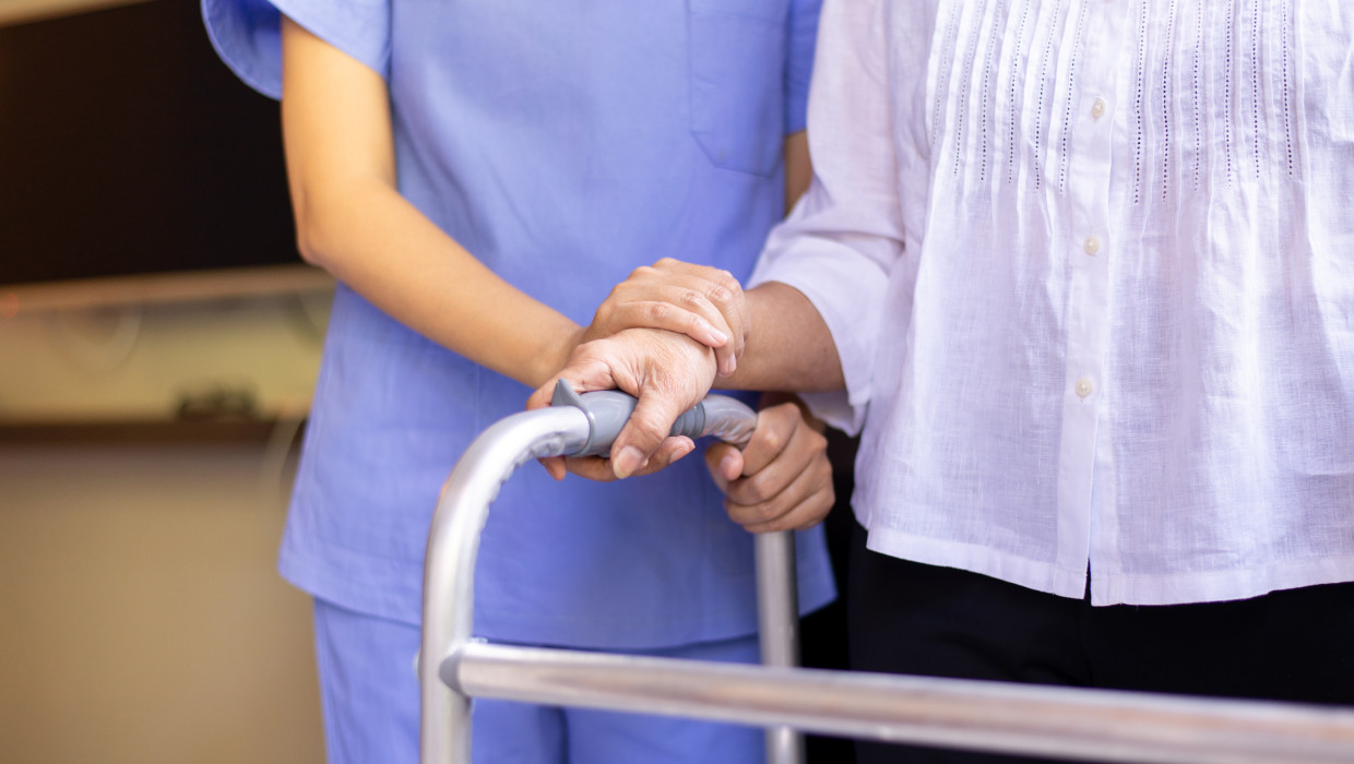Enfermera ayudando a una mujer mayor con andador