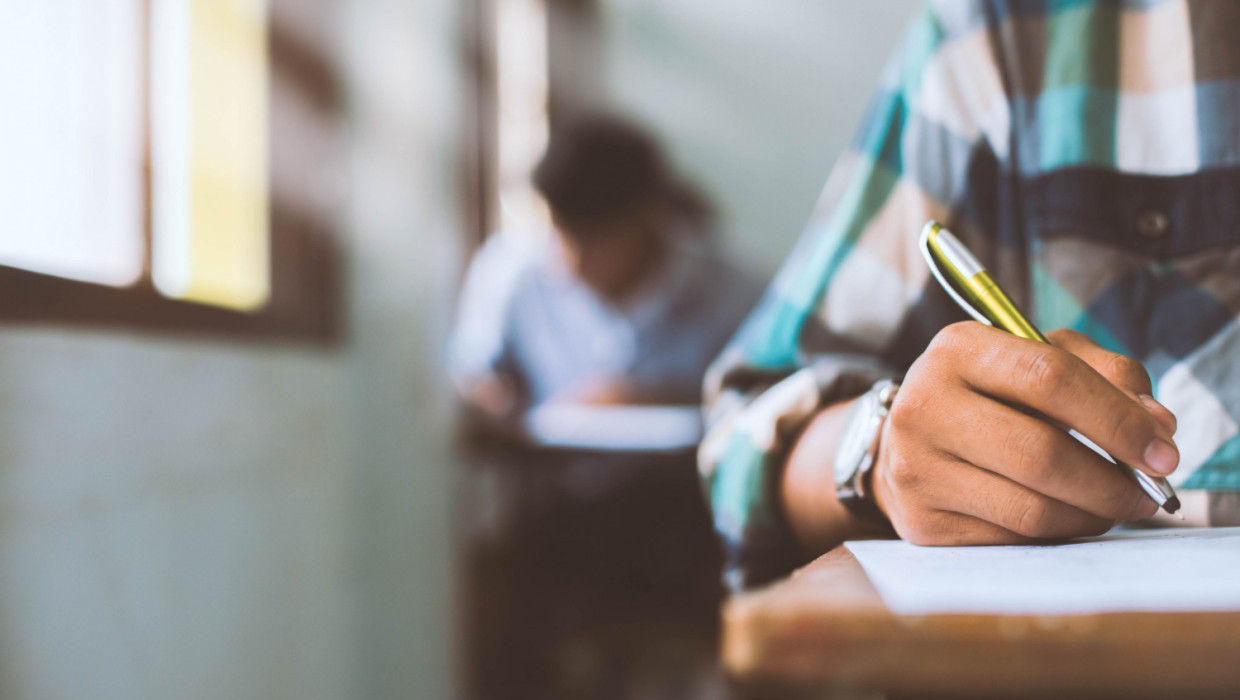 primer plano estudiantes que escriben leen hojas respuestas examen