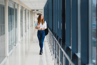 chica estudiante alegre en pasillo de la universidad