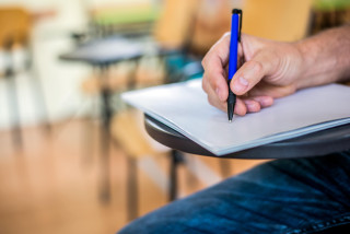 Mano de un hombre escribiendo con un bolígrafo