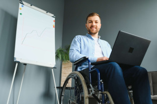 Hombre en silla de ruedas con ordenador portátil