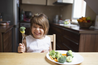 Niña comiendo verduras