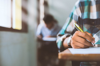 primer plano estudiantes que escriben leen hojas respuestas examen